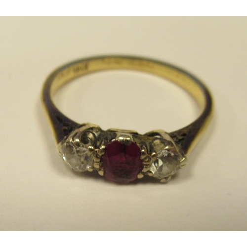 223 - A yellow metal ring, set with a central ruby, flanked by two cubic zirconias  stamped 18ct