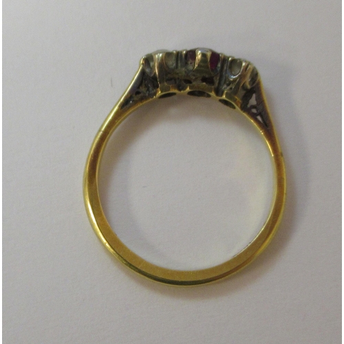 223 - A yellow metal ring, set with a central ruby, flanked by two cubic zirconias  stamped 18ct