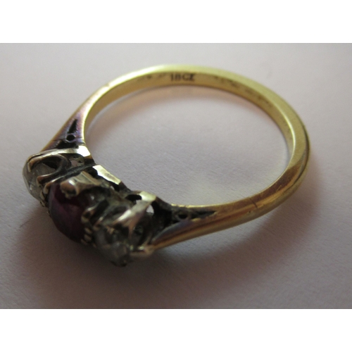 223 - A yellow metal ring, set with a central ruby, flanked by two cubic zirconias  stamped 18ct