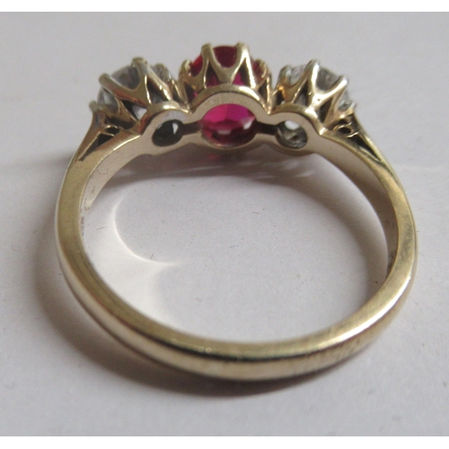 24 - A 9ct gold ring, claw set with a simulated ruby, flanked by two cubic zirconias  boxed 