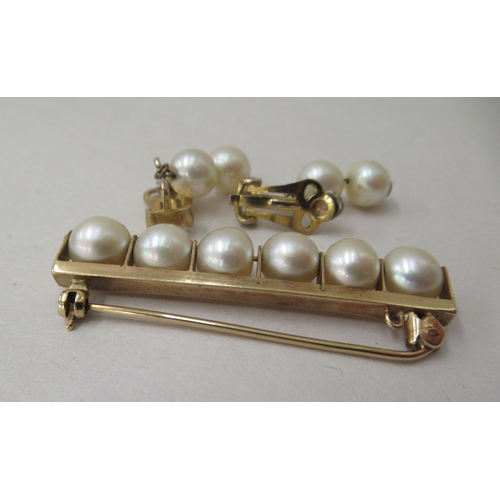 261 - A gold coloured metal bar brooch, set with six inline pearls; and a pair of twin bead pearl drop cli... 