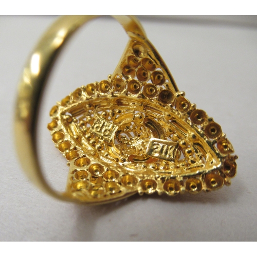 296 - A yellow Asian inspired metal ring, decorated with wire and beadwork  stamped 21K