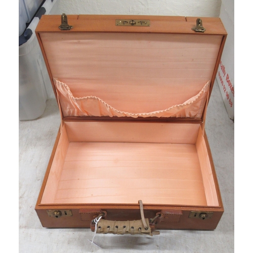 31 - An inter-war period vanity case, in a tan coloured stitched hide with a part fitted interior; and en... 