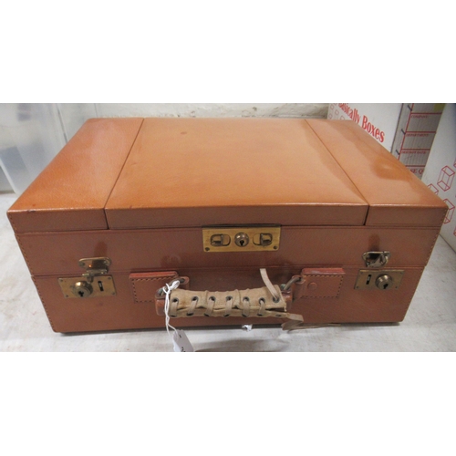 31 - An inter-war period vanity case, in a tan coloured stitched hide with a part fitted interior; and en... 