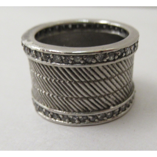 310 - A silver wide band design ring, set with two parallel rows of white stones