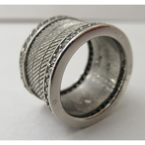 310 - A silver wide band design ring, set with two parallel rows of white stones