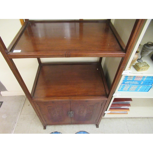 335 - A modern Asian influenced mahogany three tier stand, on square section supports and a base cupboard,... 