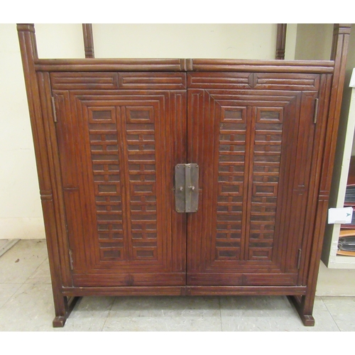 335 - A modern Asian influenced mahogany three tier stand, on square section supports and a base cupboard,... 