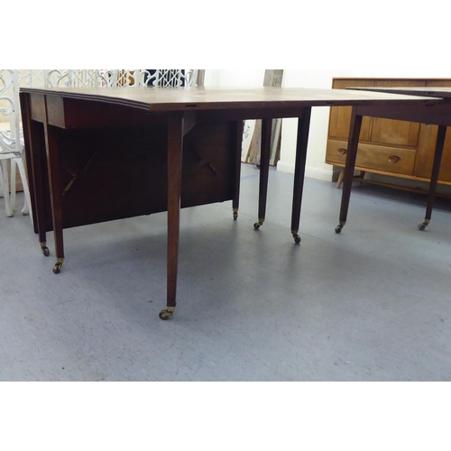 340 - A George III mahogany dining table, comprising a drop leaf centre section and two D-ends, raised on ... 