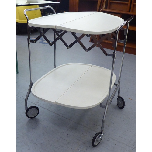 342 - A Kartell Design of Italy, two tier cream coloured folding tea trolley, raised on a chromium plated ... 