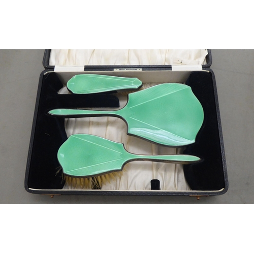 373 - A three piece silver and green enamel backed dressing table set  Birmingham 1936  cased