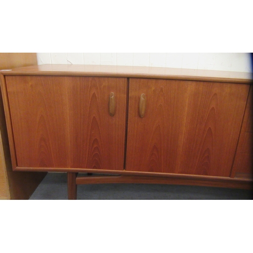 38 - A G-Plan teak sideboard, comprising a pair of cupboard doors, an adjacent bank of four drawers and a... 