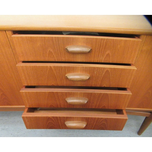 38 - A G-Plan teak sideboard, comprising a pair of cupboard doors, an adjacent bank of four drawers and a... 