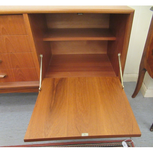 38 - A G-Plan teak sideboard, comprising a pair of cupboard doors, an adjacent bank of four drawers and a... 