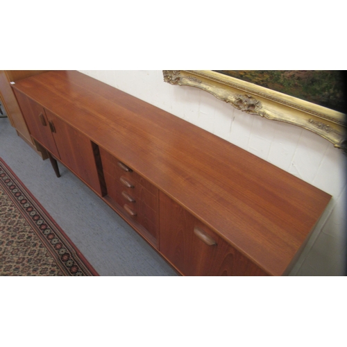 38 - A G-Plan teak sideboard, comprising a pair of cupboard doors, an adjacent bank of four drawers and a... 