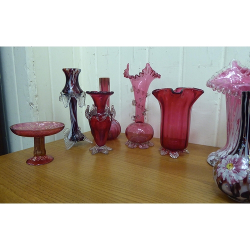 4 - Cranberry and similarly coloured glass of varying designs: to include a pair of bottle vases, decora... 