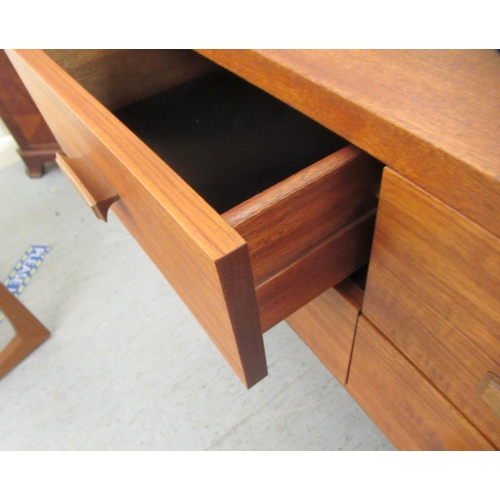 44 - A G-Plan teak dressing table, the unframed tilting mirror over six short and long drawers, raised on... 