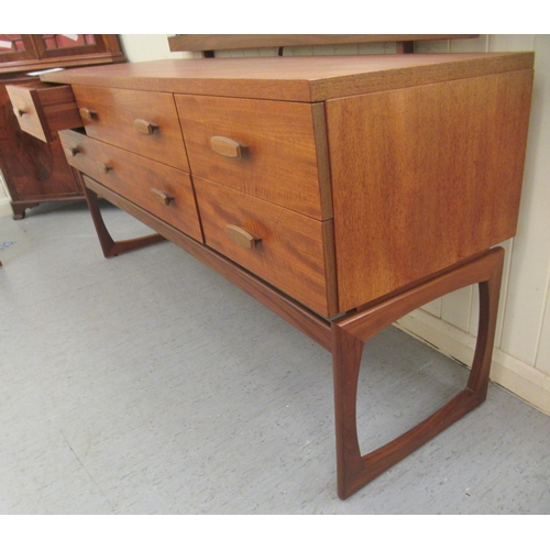 44 - A G-Plan teak dressing table, the unframed tilting mirror over six short and long drawers, raised on... 