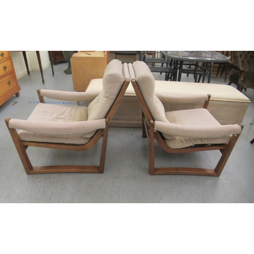 46 - A pair of 1960s/1970s Guy Rogers teak framed and cushion upholstered, open arm easy chairs 