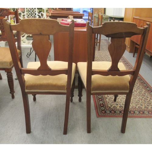 49 - A late Victorian set of six carved mahogany framed boudoir chairs, each with a bar crest and vase sh... 