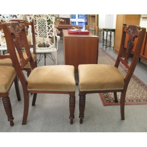 49 - A late Victorian set of six carved mahogany framed boudoir chairs, each with a bar crest and vase sh... 