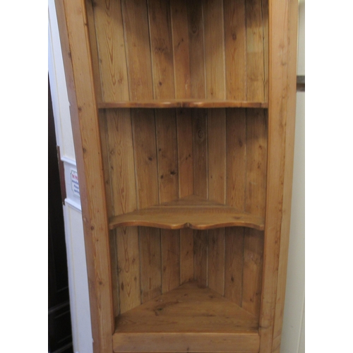 5 - A waxed pine standing corner cupboard, the upper part with open shelves, over two panelled doors&nbs... 