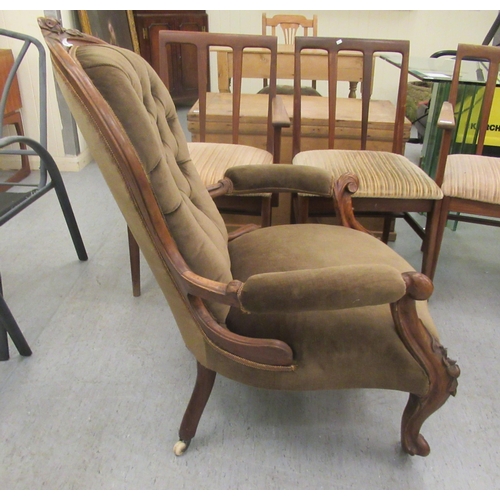 50 - A late Victorian floral and scroll carved walnut showwood framed spoonback chair with open arms, par... 