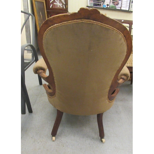 50 - A late Victorian floral and scroll carved walnut showwood framed spoonback chair with open arms, par... 