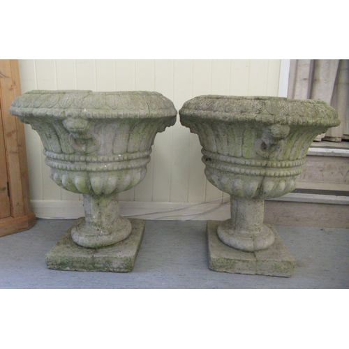 68 - A pair of composition stone pedestal planters, on square plinths  24