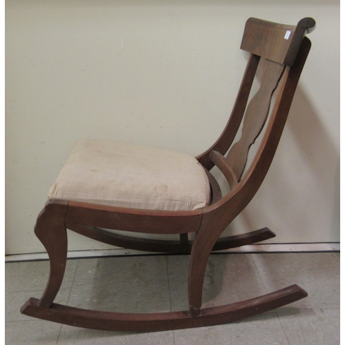 7 - A 19thC and later mahogany framed rocking chair with a curved bar crest and vase design splat, the u... 