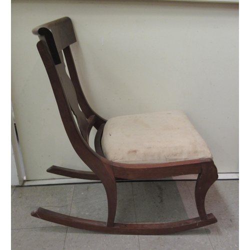 7 - A 19thC and later mahogany framed rocking chair with a curved bar crest and vase design splat, the u... 