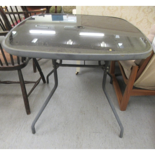 80 - A modern grey painted patio table with a glass inset, raised on splayed legs  30