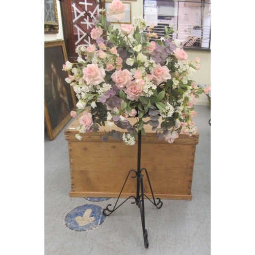 82 - A faux floral display, on a wrought metal stand  52