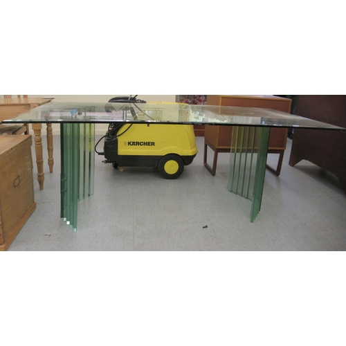 86 - A modern tinted green glass dining table, raised on concave pedestals  30