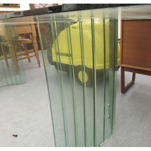 86 - A modern tinted green glass dining table, raised on concave pedestals  30