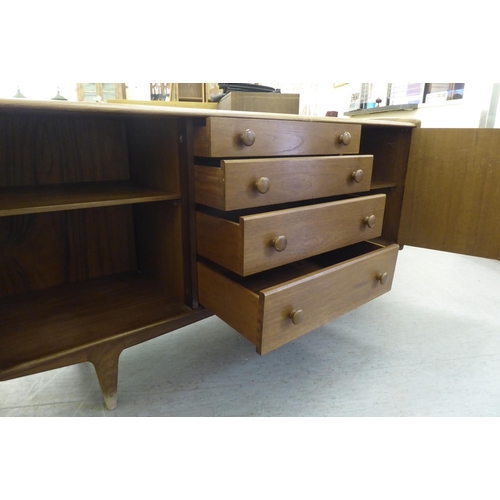 89 - A 1970s teak bow front sideboard with a central bank of four drawers, flanked by two doors, raised o... 