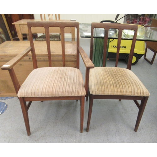 97 - A set of six 1970s teak framed dining chairs, the fabric upholstered seats raised on tapered legs  c... 