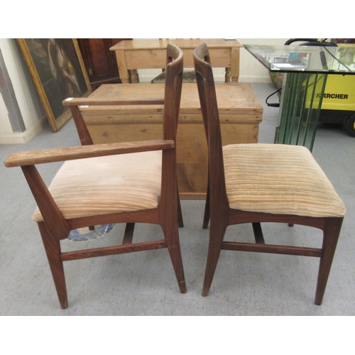 97 - A set of six 1970s teak framed dining chairs, the fabric upholstered seats raised on tapered legs  c... 