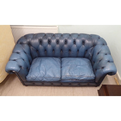 142 - A modern Chesterfield three person settee, part button and stud upholstered in blue hide  70