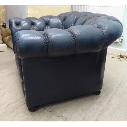 143 - A modern Chesterfield style  enclosed armchair, part button and stud upholstered in blue hide