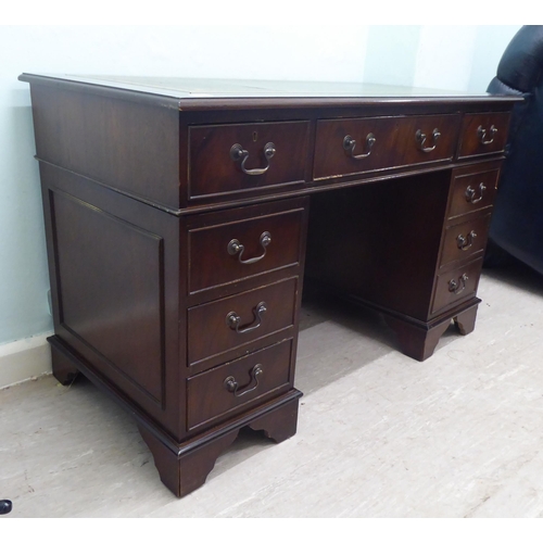 145 - A modern mahogany finished, nine drawer, twin pedestal desk, raised on bracket feet  31