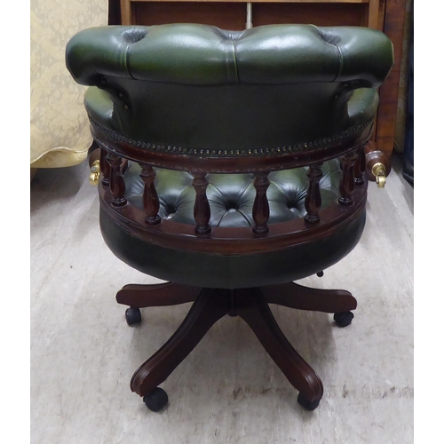 146 - A modern mahogany finished, framed Captains style rotating desk chair, upholstered in stud and butto... 