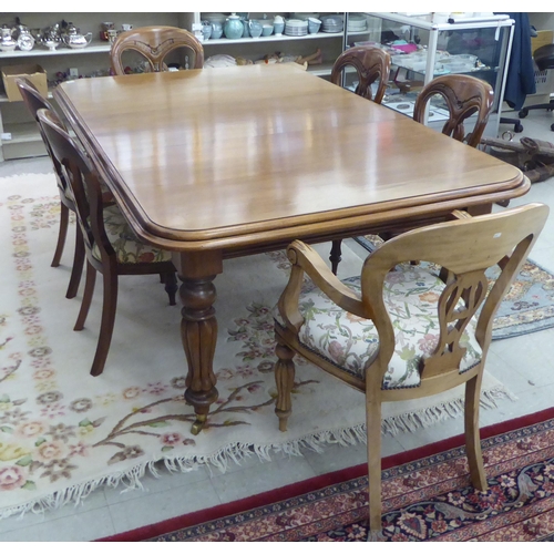 155 - A reproduction of a late Victorian mahogany dining table, raised on bulbous, reeded, tapered legs an... 