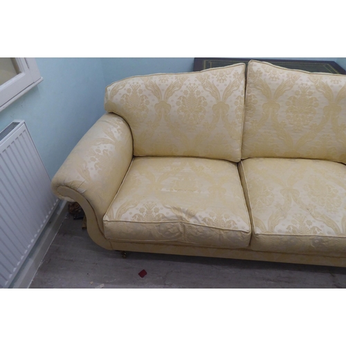 164 - A modern Omega Furniture three person settee, upholstered in patterned cream coloured fabric, raised... 