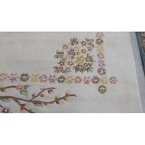 276 - A modern woollen rug, decorated with flora, on a cream coloured ground  74