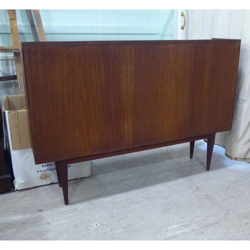 99 - A 1970s teak, open front two section bookcase, raised on tapered legs  36