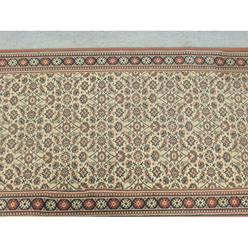 79 - A machine made Persian design runner, decorated with repeating floral designs, on a multi-coloured g... 