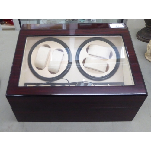 101 - An eclectic walnut finished watch winder/storage case, the hinged lid enclosing two timed, clockwise... 