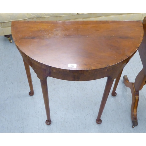 283 - Small furniture: to include a 1930s walnut demi-lune card table with a foldover top, raised on turne... 