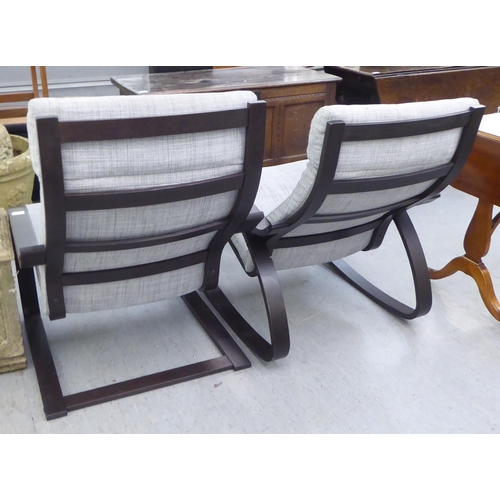 288 - A pair of modern stained beech framed cantilever design arm chairs, upholstered in grey fabric 